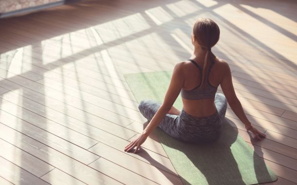 Woman doing yoga in bright sun lit room